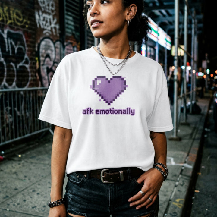 Translation missing: en.White t-shirt featuring a purple pixel art glitch heart with lowercase text reading afk emotionally