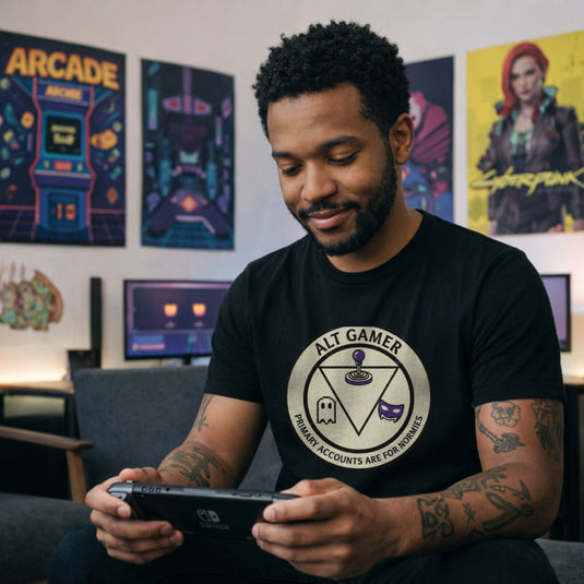 Translation missing: en.Black t-shirt with a retro arcade badge reading Alt Gamer Primary Accounts Are For Normies with purple joystick