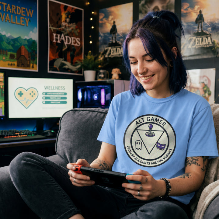 Translation missing: en.Carolina blue t-shirt with a retro arcade badge reading Alt Gamer Primary Accounts Are For Normies with purple joystick