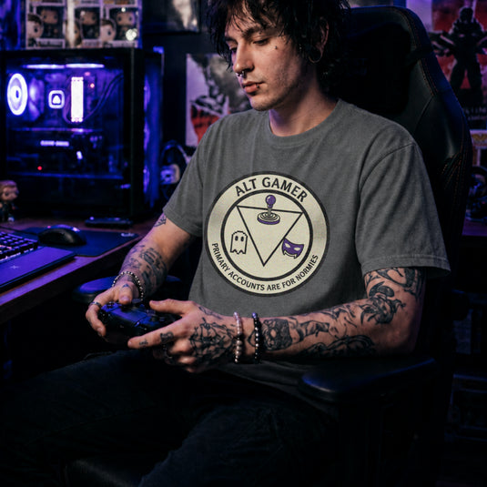 Translation missing: en.Graphite Heather t-shirt with a retro arcade badge reading Alt Gamer Primary Accounts Are For Normies with purple joystick