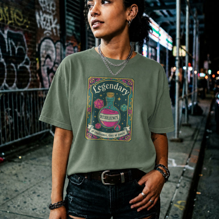 Translation missing: en.Military green cotton tee with dice and resilience potion tarot card graphic and text, "Legendary at resilience, tiny at panic"