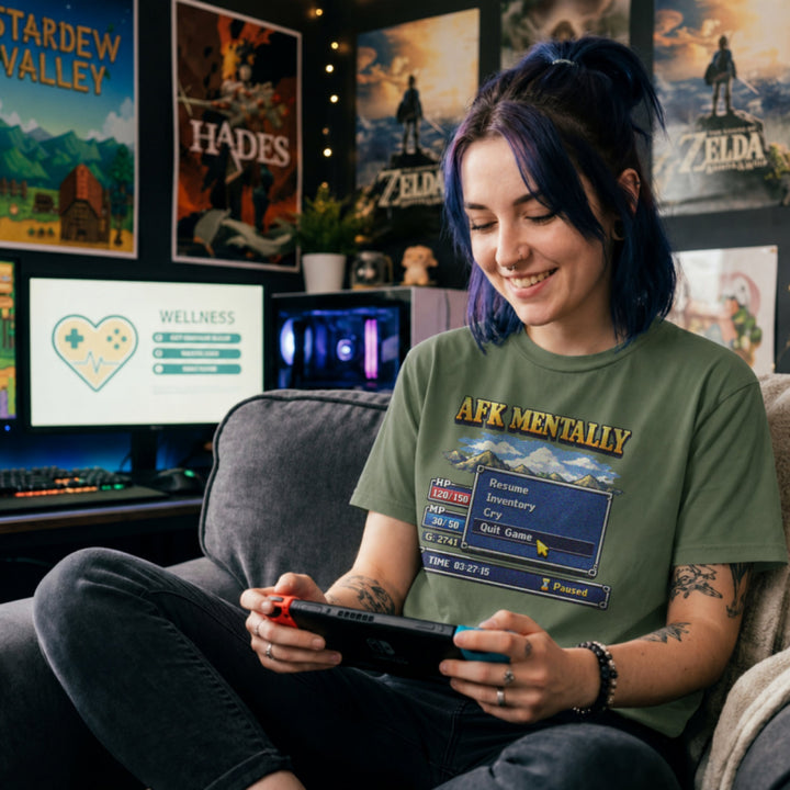 Translation missing: en.Military green tee with gold AFK Mentally text over a pixel art retro RPG menu box with a cursor hovering on Quit Game