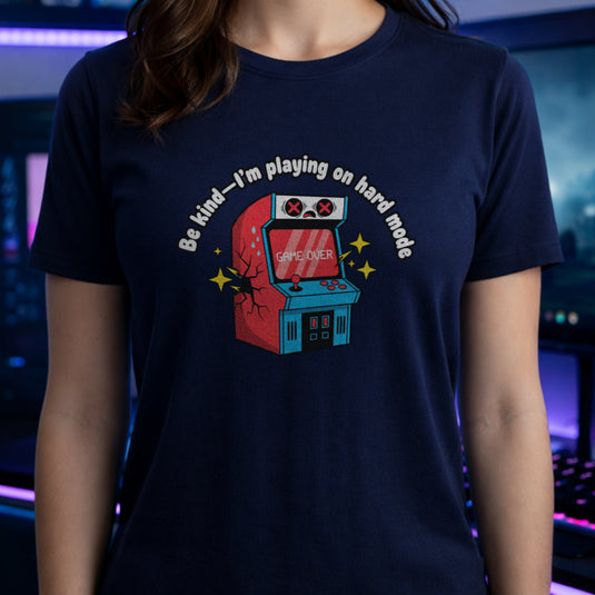 Translation missing: en.Navy shirt with text Be kind—I'm playing on hard mode above a cracked retro arcade cabinet with Game Over