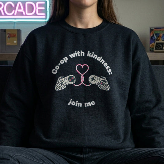 Translation missing: en.Black unisex crewneck sweatshirt with gamepad heart graphic reading, co-op with kindness join me