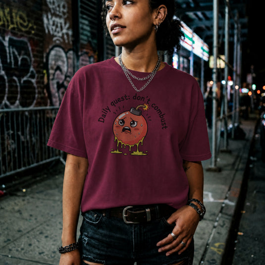 Translation missing: en.Maroon tee with cute sweating cartoon bomb graphic reading Daily quest: don't combust