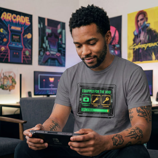 Translation missing: en.Charcoal t-shirt showing a retro monitor displaying inventory items Therapy, Hope, and Trauma with a 99% Stress bar