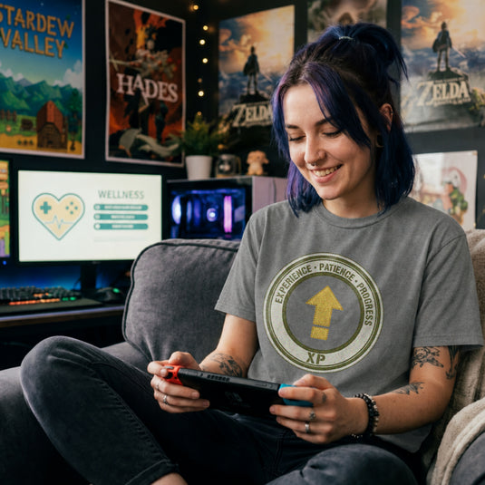 Translation missing: en.Graphite heather t-shirt with a green circular emblem reading Experience Patience Progress XP around a gold level up arrow