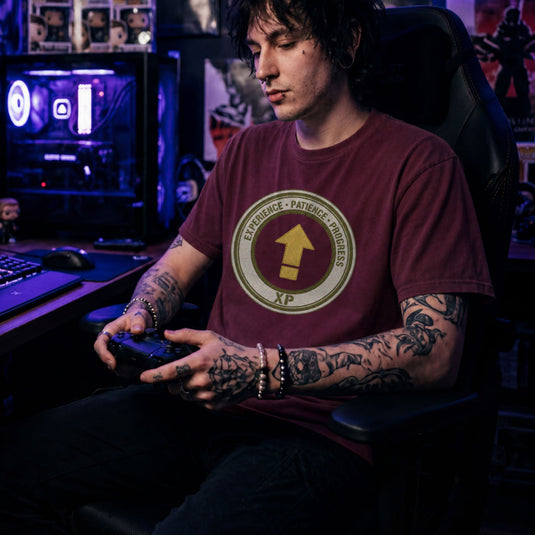 Translation missing: en.Alt n Vibe maroon t-shirt with a green circular emblem reading Experience Patience Progress XP around a gold level up arrow