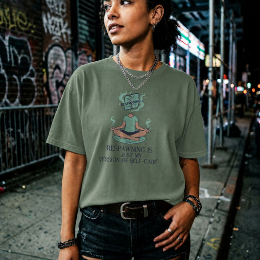 Translation missing: en.Military green gamer tee with a meditating person graphic and text Respawning is just my version of self-care