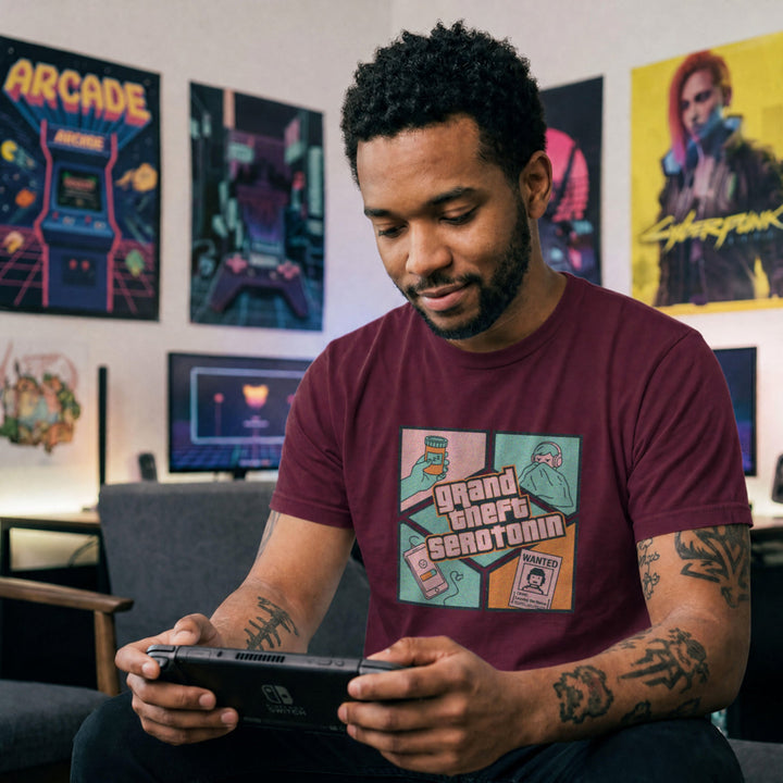Translation missing: en.Maroon gamer tee graphic Grand Theft Serotonin with a wanted poster, low battery phone, sleeping pills, and person in blanket
