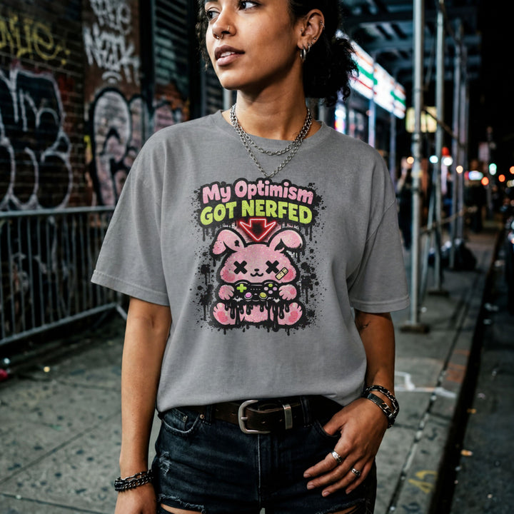 Translation missing: en. Sports grey t-shirt with a pink cartoon character and text, My Optimism Got Nerfed in a gaming-themed design