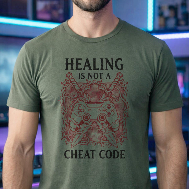Translation missing: en.Military green gamer tee graphic with crossed swords, controller, and thorns text Healing Is Not A Cheat Code. 