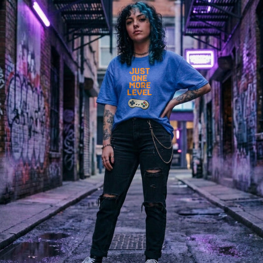 Translation missing: en.Retro heather royal t-shirt with orange pixelated text reading Just One More Level above a classic retro game controller