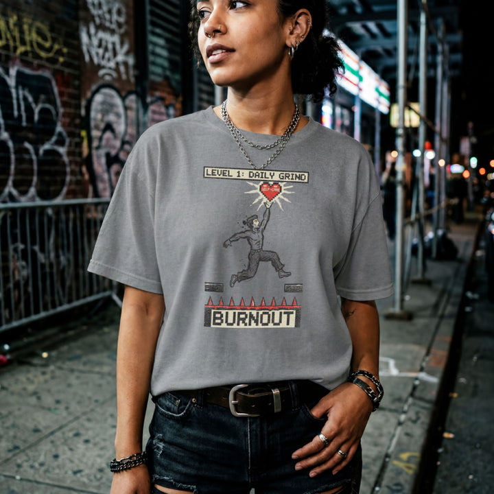 Translation missing: en.Graphite heather tee with a platformer game graphic of a man jumping over spikes labeled Burnout to reach a self-care heart