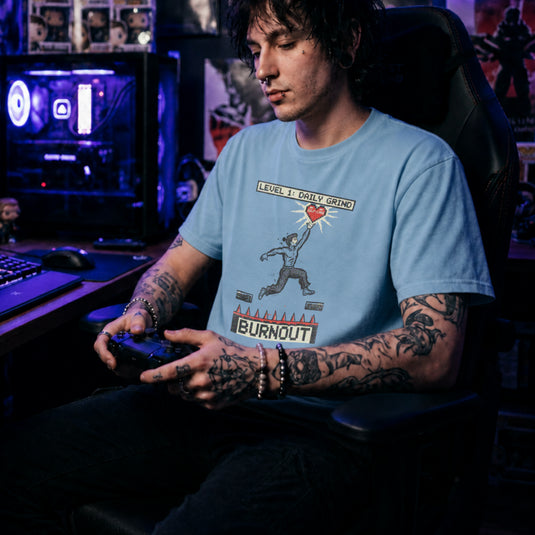 Translation missing: en.Light blue tee with a platformer game graphic of a man jumping over spikes labeled Burnout to reach a self-care heart
