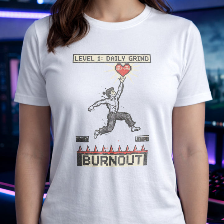 Translation missing: en.White tee with a platformer game graphic of a man jumping over spikes labeled Burnout to reach a self-care heart