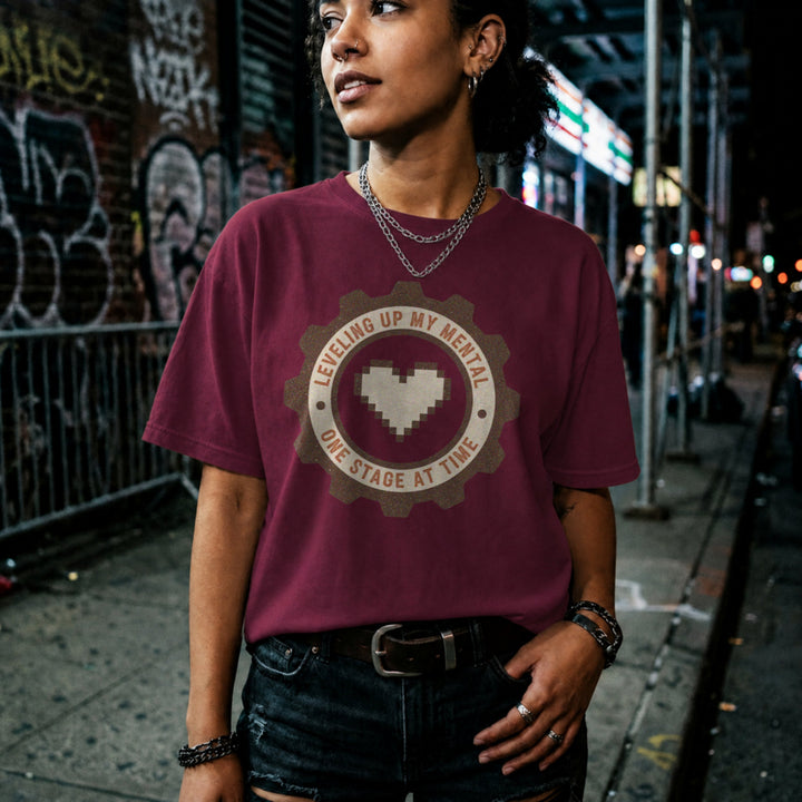 Translation missing: en.Maroon tee with pixel heart centered in cog badge graphic text, "leveling up my mental one stage at a time"