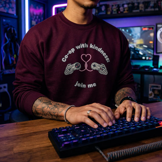 Translation missing: en.Maroon unisex crewneck sweatshirt with gamepad heart graphic reading, co-op with kindness join me