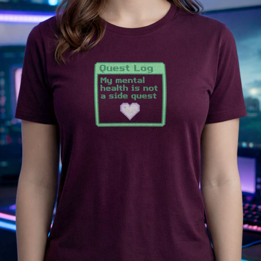 Translation missing: en.Maroon shirt with a green pixel art quest log graphic reading My mental health is not a side quest with a heart