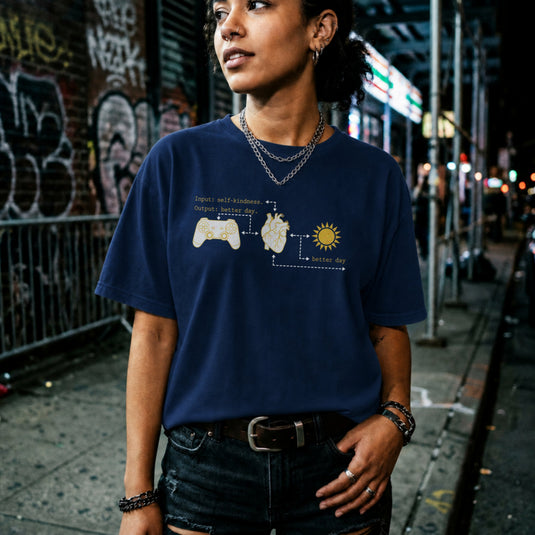 Translation missing: en.Navy tee with gold flowchart connecting a game controller, anatomical heart, sun, and text Input self-kindness