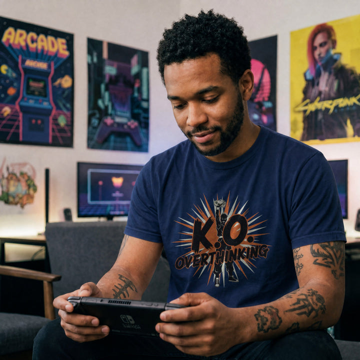Translation missing: en.Navy shirt with a silhouette fighter holding a controller high, starburst graphic, and text K.O. Overthinking