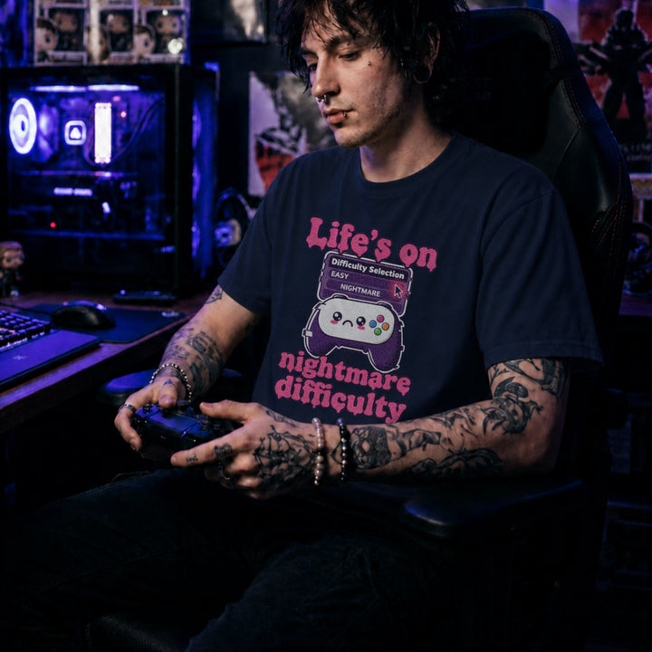 Translation missing: en.Navy tee with pink text reading Life's on nightmare difficulty next to a sad controller and difficulty selector