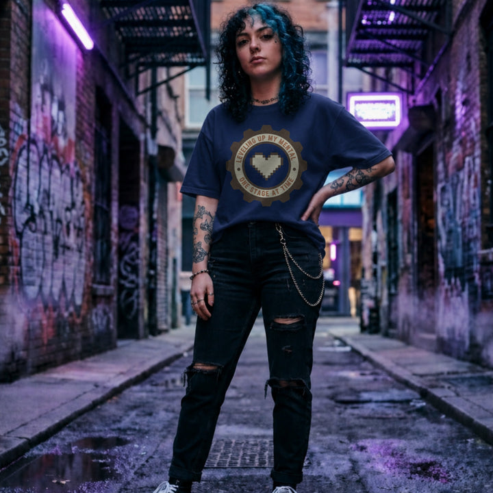 Translation missing: en.Navy tee with pixel heart centered in cog badge graphic text, "leveling up my mental one stage at a time"