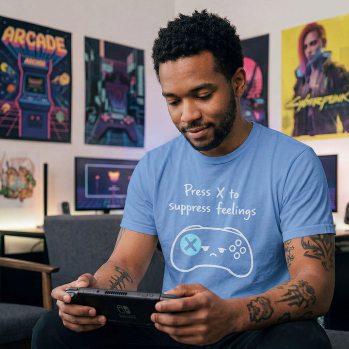 Translation missing: en.Carolina blue gamer shirt graphic showing a sad video game controller with text reading Press X to suppress feelings. 