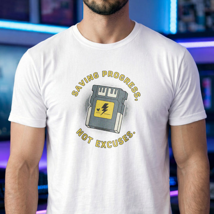 Translation missing: en.White t-shirt with yellow text reading Saving Progress, Not Excuses around a retro console memory card icon