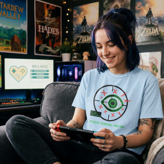 Translation missing: en.Green eye in a crosshair target with red Xs, a green kill feed text box, and Schizo Sensing on a light blue tee shirt