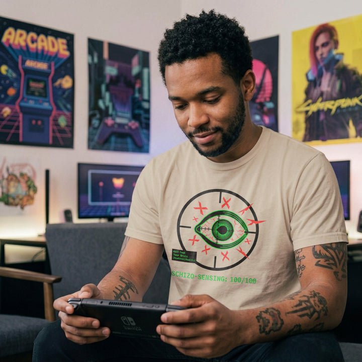 Translation missing: en.Green eye in a crosshair target with red Xs, a green kill feed text box, and Schizo Sensing on a sand tee shirt