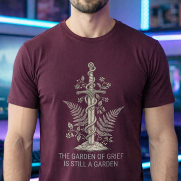 Translation missing: en.Maroon t-shirt graphic with sword wrapped in vines and ferns reading The Garden Of Grief Is Still A Garden