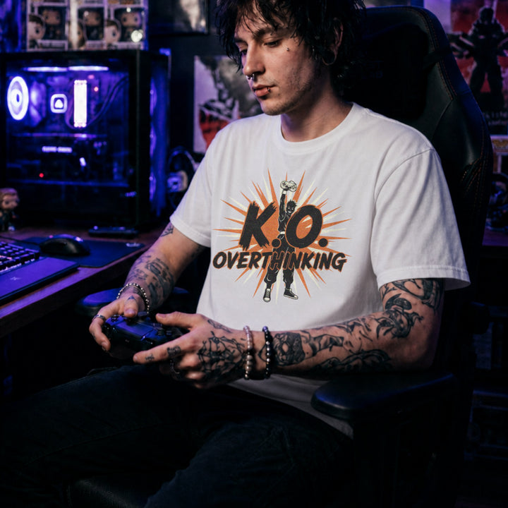 Translation missing: en.White shirt with a silhouette fighter holding a controller high, starburst graphic, and text K.O. Overthinking