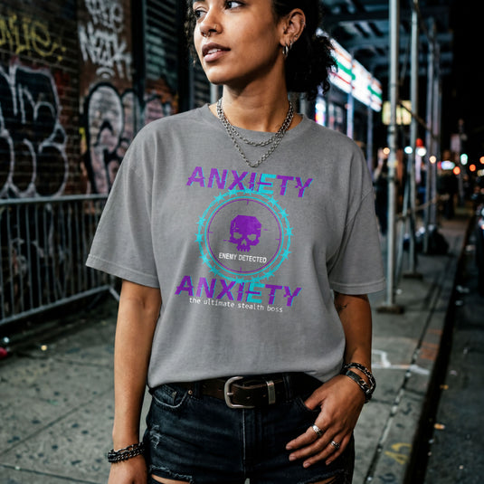 Translation missing: en.Purple and teal pixelated glitch text reading Anxiety Enemy Detected on a graphite heather graphic gamer tee