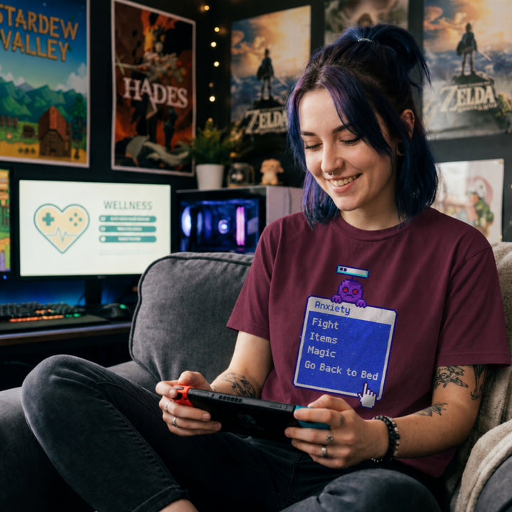 Translation missing: en.Maroon t-shirt featuring a retro blue RPG battle menu box titled Anxiety with option Go Back to Bed