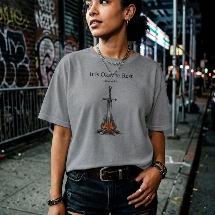 Translation missing: en.Graphite Heather t-shirt with a sword in a bonfire graphic and text reading It is Okay to Rest and Bonfire Lit