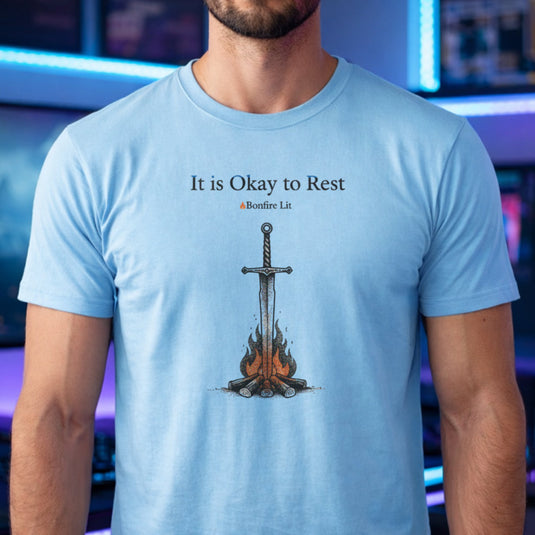 Translation missing: en.Alt n Vibe light blue t-shirt with a sword in a bonfire graphic and text reading It is Okay to Rest and Bonfire Lit