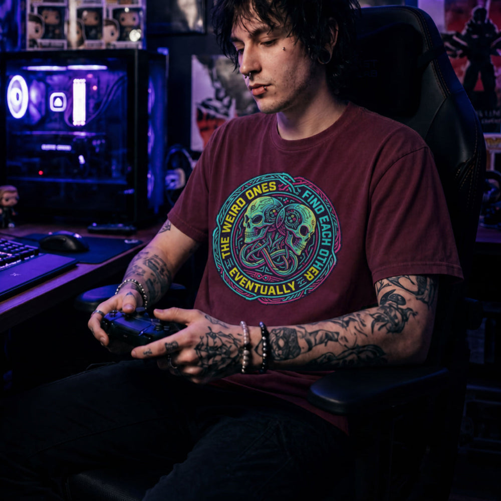 Translation missing: en.Maroon t-shirt with neon cyber skulls emblem and text: The weird ones find each other eventually gaming graphic