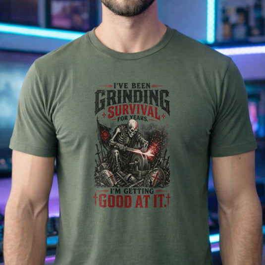 Translation missing: en.Military green t-shirt with skeleton warrior sharpening sword on grindstone graphic and text: Grinding survival for years