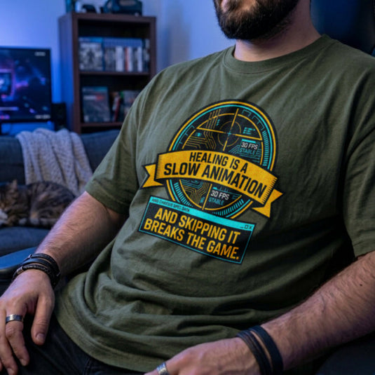 Translation missing: en.Military green t-shirt with yellow and cyan tech HUD UI graphic and text: Healing is a slow animation, skipping it breaks game