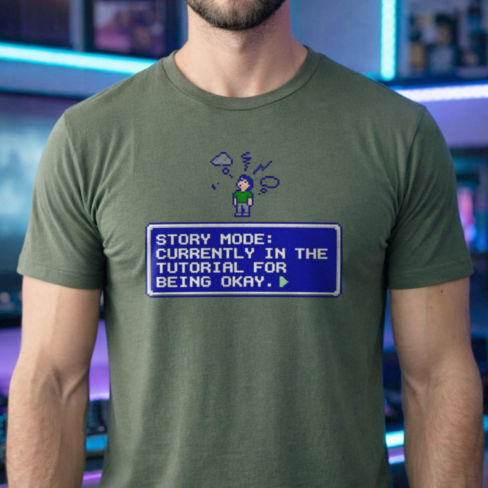 Translation missing: en.Military green t-shirt with pixel art character, thought cloud, and RPG text box: Story Mode tutorial for being okay