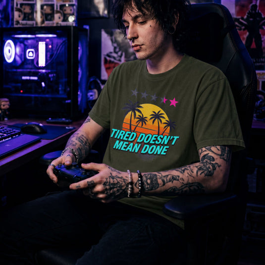 Translation missing: en.Military green t-shirt with retro palm tree sunset graphic and text: Tired Doesn't Mean Done with 5-star rating graphic