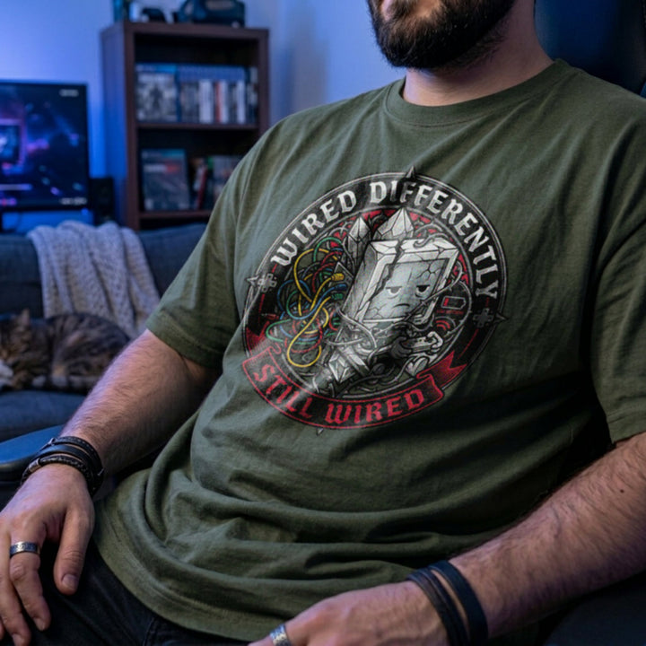Translation missing: en.Miliary green t-shirt with a retro computer monitor character holding a controller surrounded by tangled colorful wires