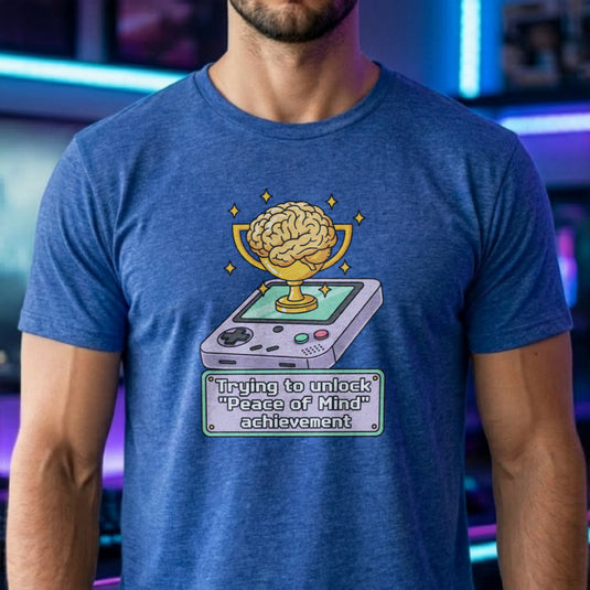 Translation missing: en.Heather royal t-shirt featuring a retro handheld console with a brain trophy and Peace of Mind achievement text box