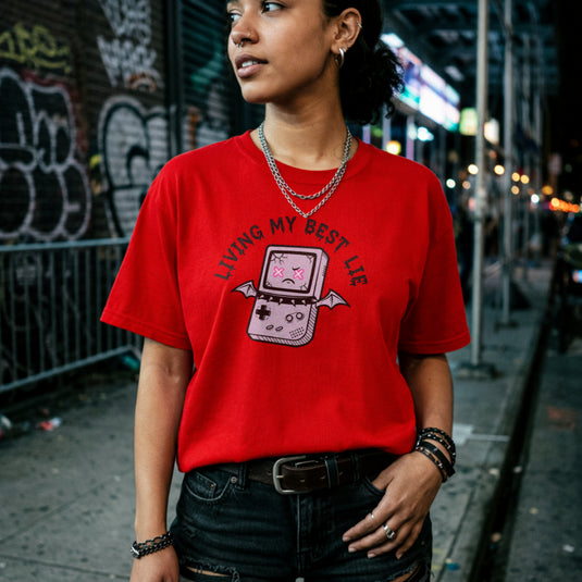 Translation missing: en.Red  t-shirt with a cracked retro handheld console graphic with bat wings and text Living My Best Lie