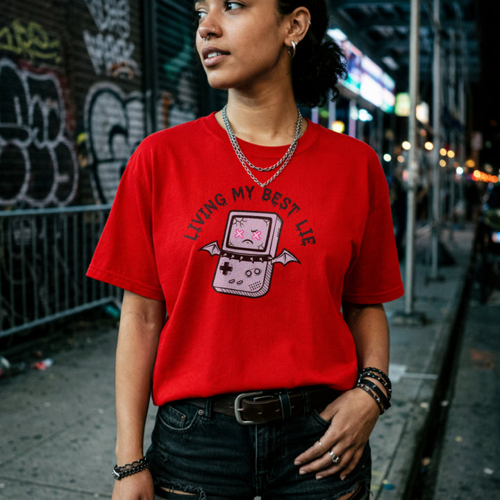 Translation missing: en.Red  t-shirt with a cracked retro handheld console graphic with bat wings and text Living My Best Lie