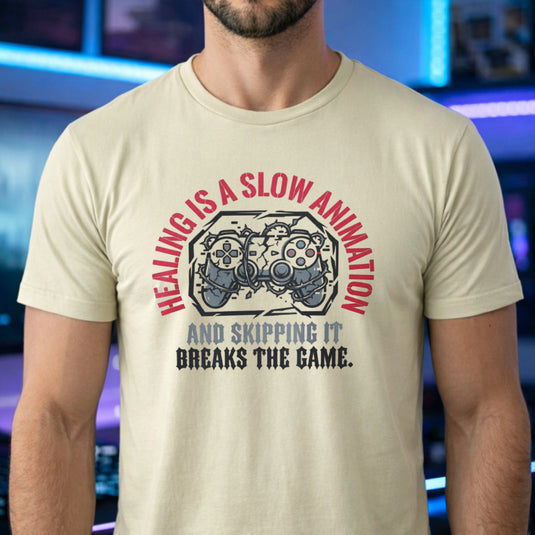 Translation missing: en.Sand t-shirt with cracked game controller wrapped in thorns and text: Healing is a slow animation, skipping breaks the game