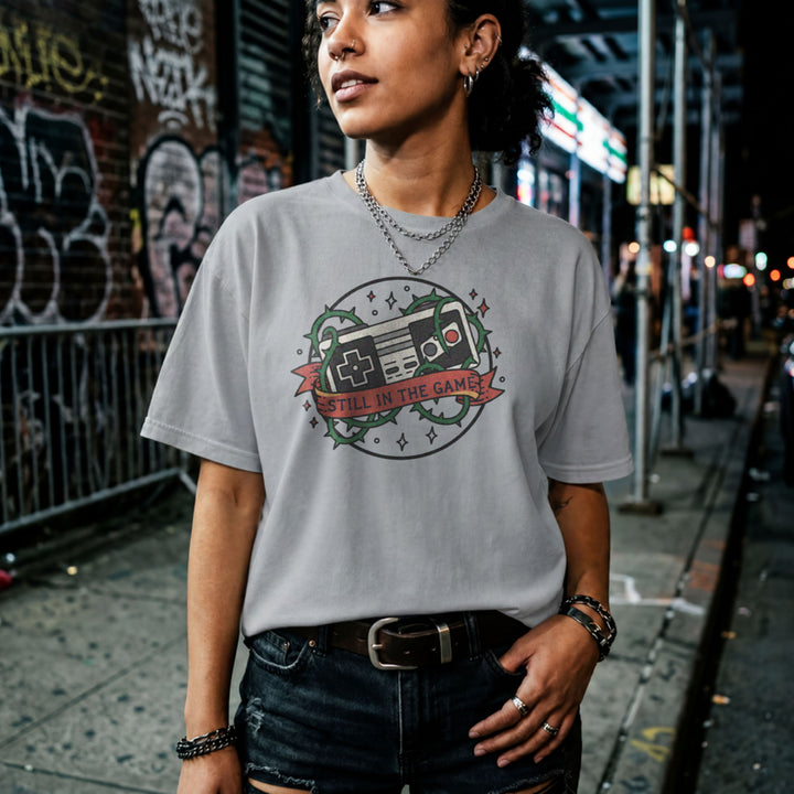 Translation missing: en.Sports grey  t-shirt with a classic retro controller tangled in green thorns and a banner reading STILL IN THE GAME. 