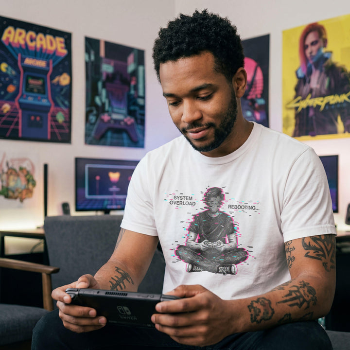Translation missing: en.White t-shirt showing a glitch art gamer sitting cross-legged with System Overload Rebooting text