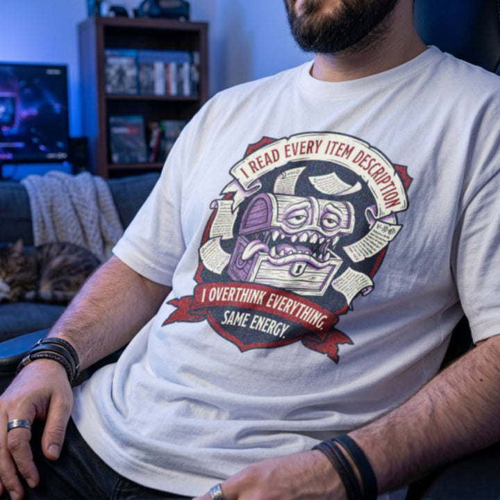 Translation missing: en.White t-shirt with an RPG mimic chest graphic surrounded by scrolls reading I Read Every Item Description